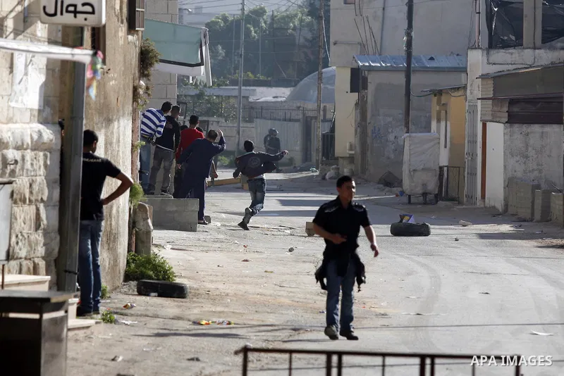 Palestinian youth throw stones towards Israeli soldiers patrolling near the shrine of Joseph's Tomb in the West Bank city of Nablus on April 24, 2011 as clashes erupted after an Israeli worshipper was shot dead by Palest...