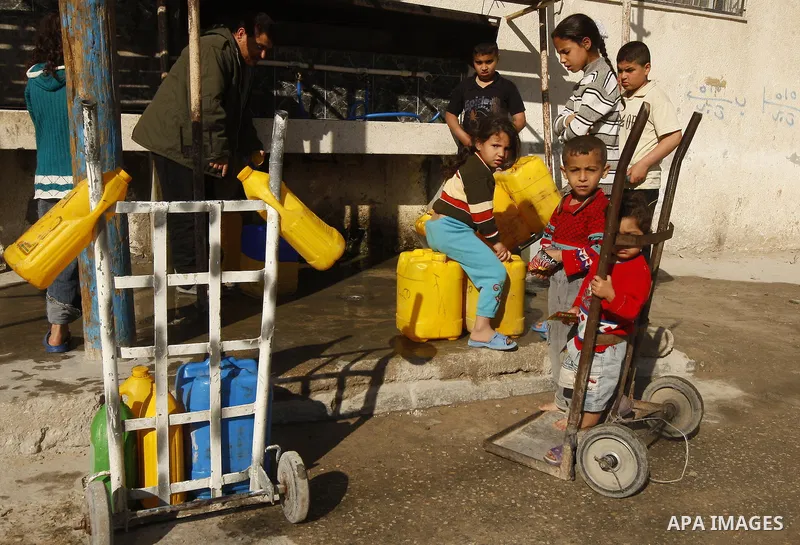 Palestinians fill bottles with water from a public tap in the United Nations Relief and Works Agency (UNRWA) headquarters in Rafah refugee camp in the southern of Gaza strip on April 26, 2011. Photo by Abed Rahim Khatib
