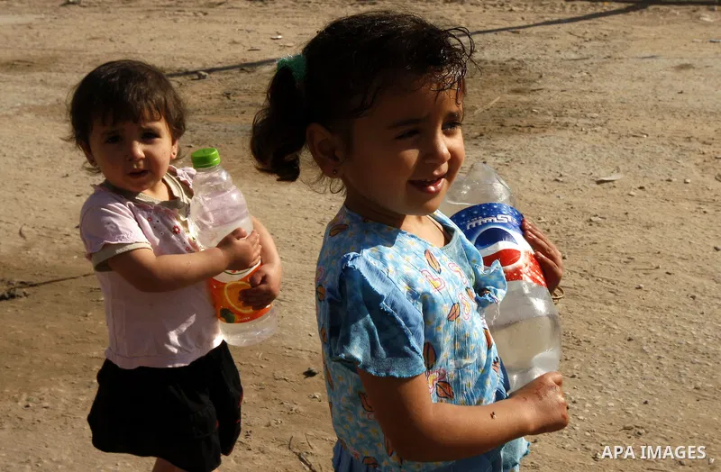 A Palestinian girl fill bottles with water from a public tap in the United Nations Relief and Works Agency (UNRWA) headquarters in Rafah refugee camp in the southern of Gaza strip on April 26, 2011. Photo by Abed Rahim K...