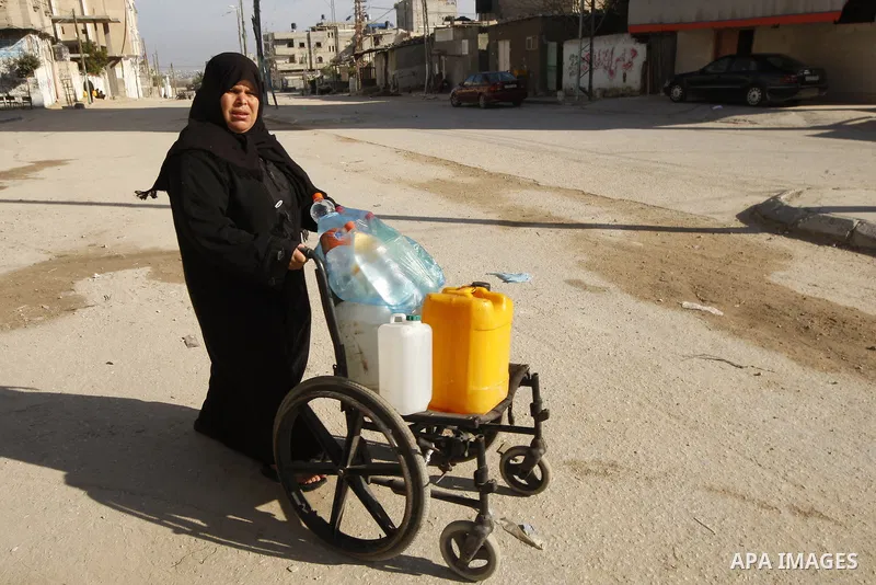 A Palestinian woman fill bottles with water from a public tap in the United Nations Relief and Works Agency (UNRWA) headquarters in Rafah refugee camp in the southern of Gaza strip on April 26, 2011. Photo by Abed Rahim...