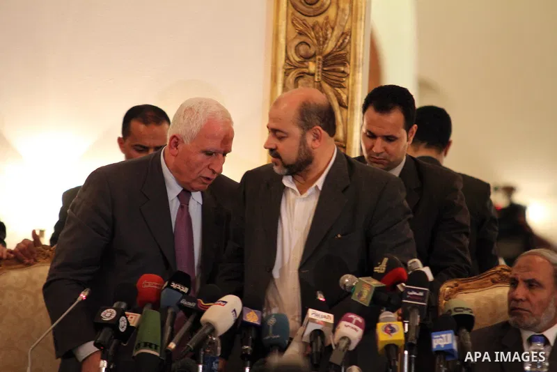 Palestinian Fatah delegation chief Azzam al-Ahmed shakes hands with Hamas deputy leader Mussa Abu Marzuq after a joint press conference in Cairo on April 27, 2011 as the rival Palestinian groups reached an "understanding...
