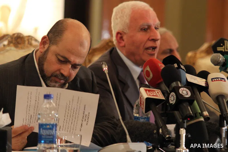 Palestinian Fatah delegation chief Azzam al-Ahmed speaks during a joint press conference with Hamas deputy leader Mussa Abu Marzuq and senior Hamas member Mahmud Zahar in Cairo on April 27, 2011 as the rival Palestinian...