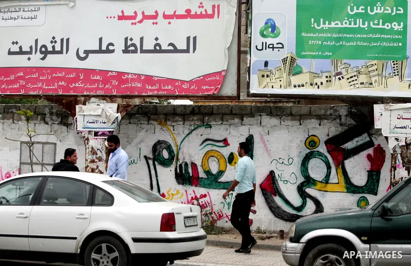 A Palestinian man walks past graffiti reading in Arabic, "Yes to the end of the division", in Gaza City on April 28, 2011 as Palestinians in the Gaza Strip and the West Bank welcomed reports that their rival Hamas and Fa...