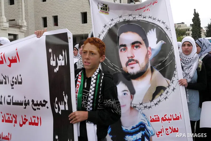 Palestinians carry pictures of their jailed relatives being held in Israel prisons during a protest calling for their release at the International Red Cross building in the West Bank city of Ramallah, April 28,2011. Phot...