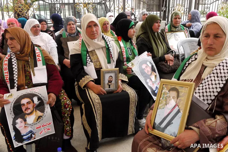 Palestinians carry pictures of their jailed relatives being held in Israel prisons during a protest calling for their release at the International Red Cross building in the West Bank city of Ramallah, April 28,2011. Phot...