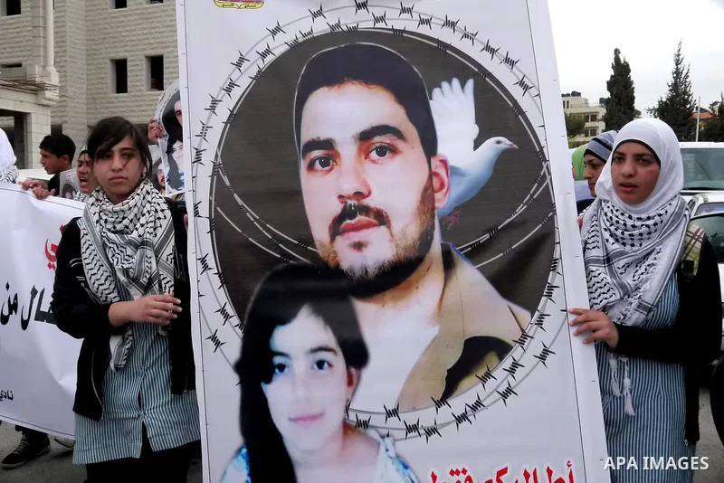 Palestinians carry pictures of their jailed relatives being held in Israel prisons during a protest calling for their release at the International Red Cross building in the West Bank city of Ramallah, April 28,2011. Phot...