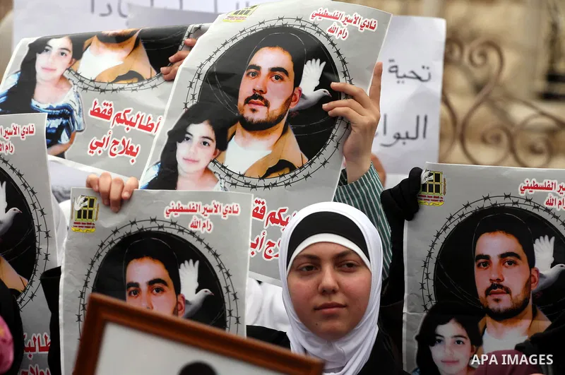 Palestinians carry pictures of their jailed relatives being held in Israel prisons during a protest calling for their release at the International Red Cross building in the West Bank city of Ramallah, April 28,2011. Phot...