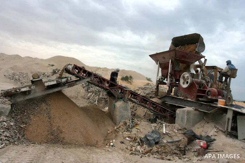 Palestinian workers smash large stones into small gravels to be used for building houses on April 28, 2011 in the southern Gaza Strip city of Khan Younis, as the coastal Palestinian territory continues to lack most const...