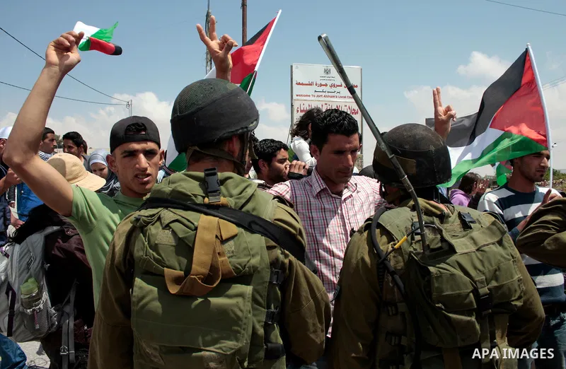 Protesters argue with Israeli soldiers during a demonstration against Israel's controversial separation barrier in the West Bank village of Maasarah, near the biblical town of Bethlehem on April 29, 2011.Israel says the...