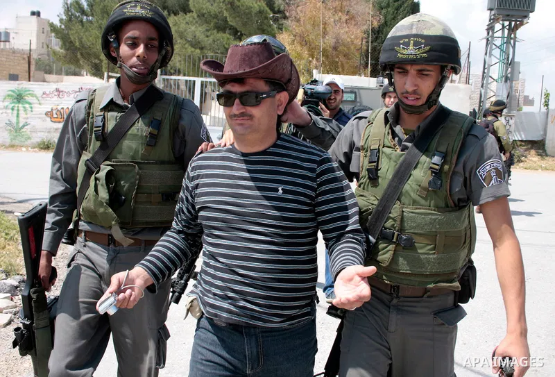 Israeli soldiers arrest a protester during a demonstration against Israel's controversial separation barrier in the West Bank village of Maasarah, near the West Bank town of Bethlehem on April 29, 2011.Israel says the ne...