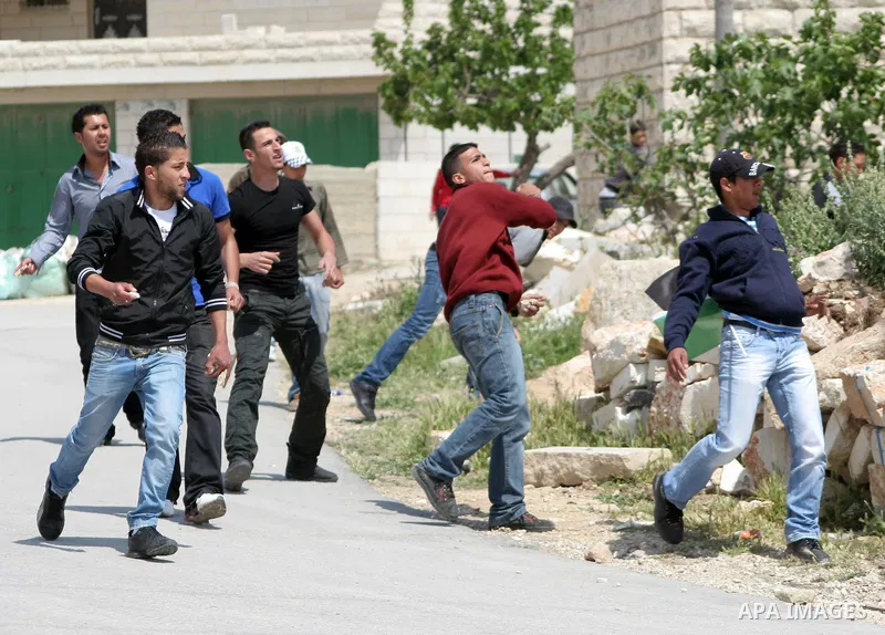 Palestinian protestors throw stons at Israeli soldiers during a demonstration against Israel's controversial separation barrier in the West Bank village of Maasarah, near the biblical town of Bethlehem on April 29, 2011....