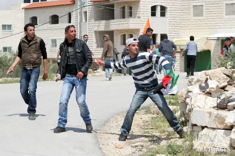 Palestinian protestors throw stons at Israeli soldiers during a demonstration against Israel's controversial separation barrier in the West Bank village of Maasarah, near the biblical town of Bethlehem on April 29, 2011....