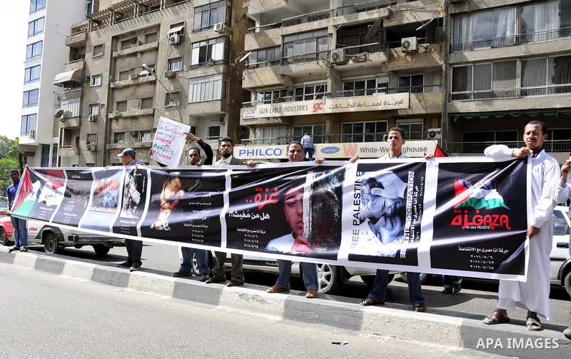 Egyptian protesters hold placards during a demonstration in front of the Israeli embassy in Cairo on April 29, 2011, calling for opening the border with the Gaza Strip and in support with Palestinian unity between Fatah...