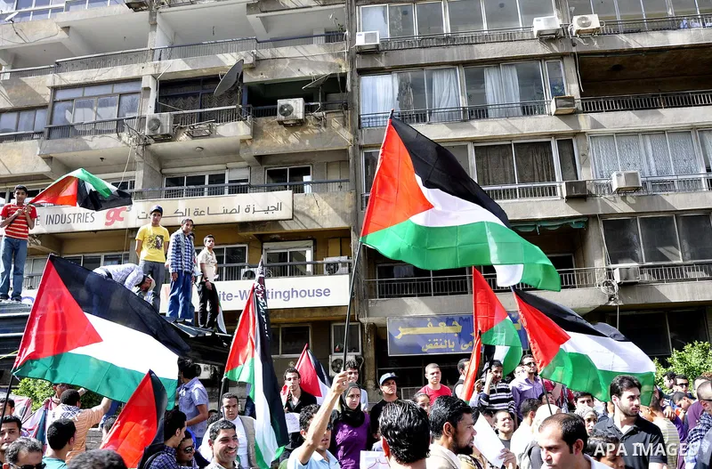 Egyptian protesters wave the Palestinian flag during a demonstration in front of the Israeli embassy in Cairo on April 29, 2011, calling for opening the border with the Gaza Strip and in support with Palestinian unity be...