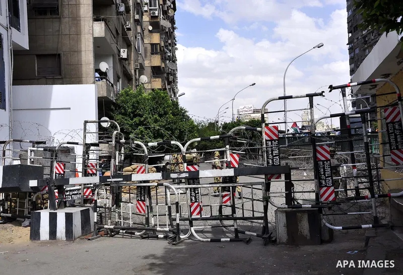 Egyptian army stands guard outside the Israeli embassy as protesters wave the Palestinian flag during a demonstration in front of the Israeli embassy in Cairo on April 29, 2011, calling for opening the border with the Ga...