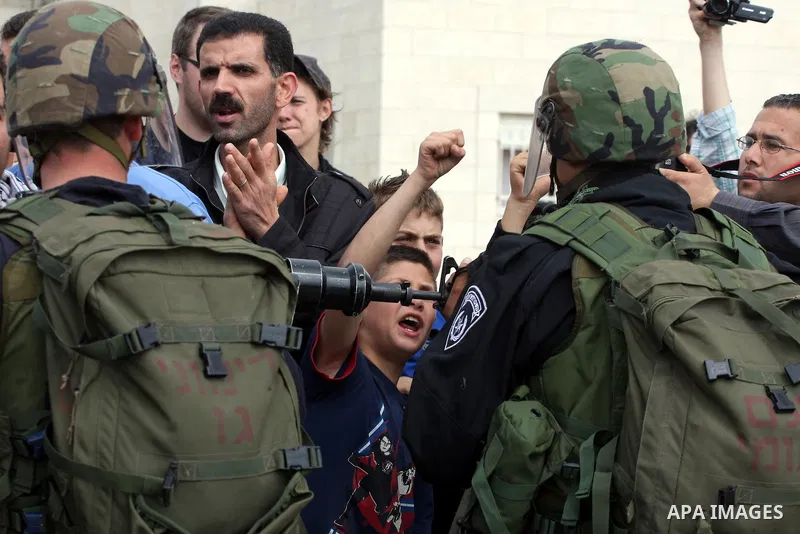 Demonstrator stand face-to-face with an Israeli soldiers during protest against the expropriation of Palestinian land to expand the Jewish settlement of Halmish on April 29, 2011 in the West Bank village of Nabi Saleh.....