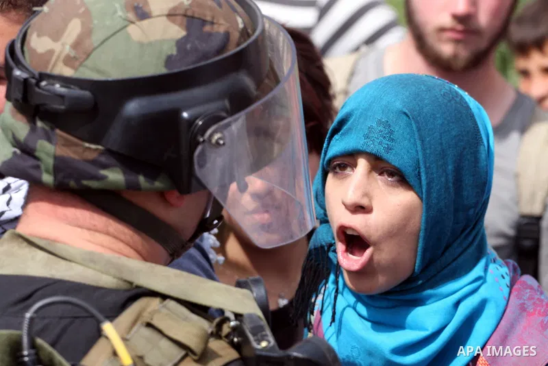 Demonstrator stand face-to-face with an Israeli soldiers during protest against the expropriation of Palestinian land to expand the Jewish settlement of Halmish on April 29, 2011 in the West Bank village of Nabi Saleh.....