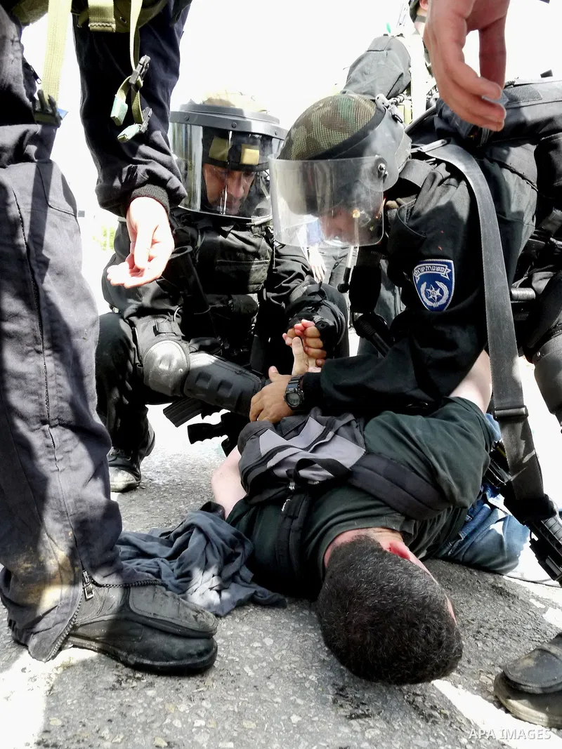 Israeli soldiers detain a pro-Palestinian activist during protest against the expropriation of Palestinian land to expand the Jewish settlement of Halmish on April 29, 2011 in the West Bank village of Nabi Saleh. Photo b...