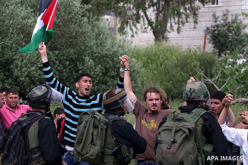 Demonstrator stand face-to-face with an Israeli soldiers during protest against the expropriation of Palestinian land to expand the Jewish settlement of Halmish on April 29, 2011 in the West Bank village of Nabi Saleh.....