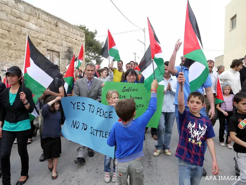 Demonstrators wave Palestinian flag during protest against the expropriation of Palestinian land to expand the Jewish settlement of Halmish on April 29, 2011 in the West Bank village of Nabi Saleh.. Photo by Issam Rimawi