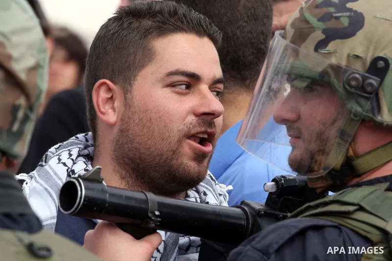 Demonstrator stand face-to-face with an Israeli soldiers during protest against the expropriation of Palestinian land to expand the Jewish settlement of Halmish on April 29, 2011 in the West Bank village of Nabi Saleh.....