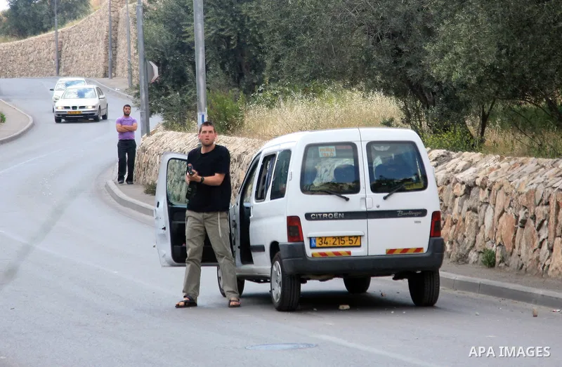 A Jewish settler gets out of his car with an assault rifle, which he fired in the air to disperse stone-throwing Palestinians who attacked him as he drove through the flashpoint east Jerusalem neighbourhood of Silwan on...