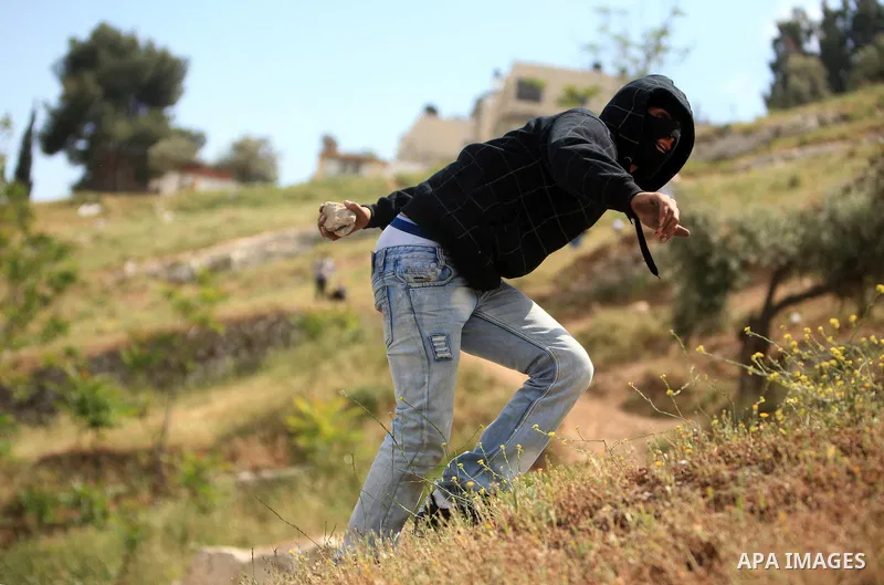 Palestinian youths hurl stones toward Israeli soldiers during clashes in the flashpoint east Jerusalem neighbourhood of Silwan on April 29, 2011.. Photo by Sliman Khader