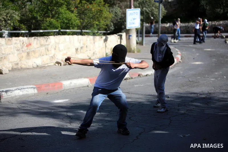 Palestinian youths hurl stones toward Israeli soldiers during clashes in the flashpoint east Jerusalem neighbourhood of Silwan on April 29, 2011.. Photo by Sliman Khader