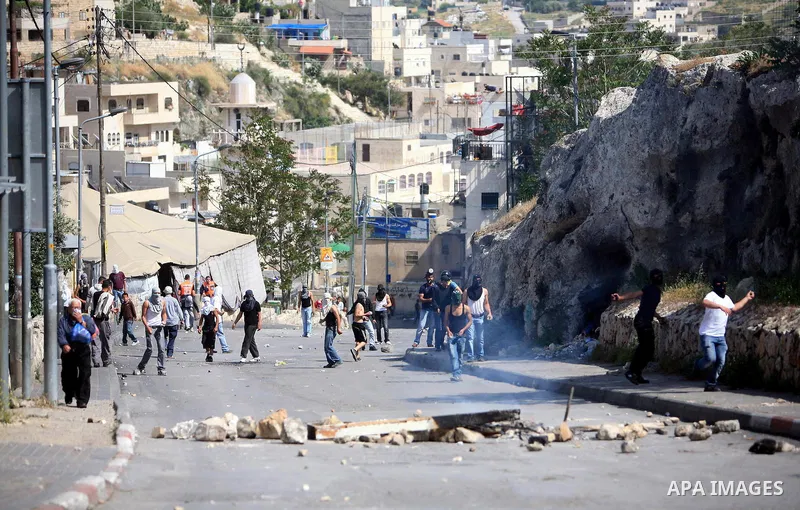 Palestinian youths hurl stones toward Israeli soldiers during clashes in the flashpoint east Jerusalem neighbourhood of Silwan on April 29, 2011.. Photo by Sliman Khader