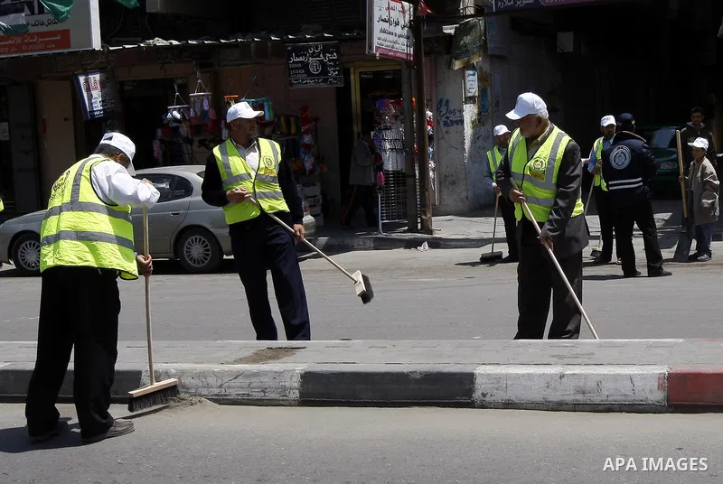 Members of the ruling Islamic Hamas movement sweep the street as volunteers took to the street in a project entitled "Gaza is the most beautiful despite the blockade" to mark workers' May Day in Rafah town In Gaza Strip,...