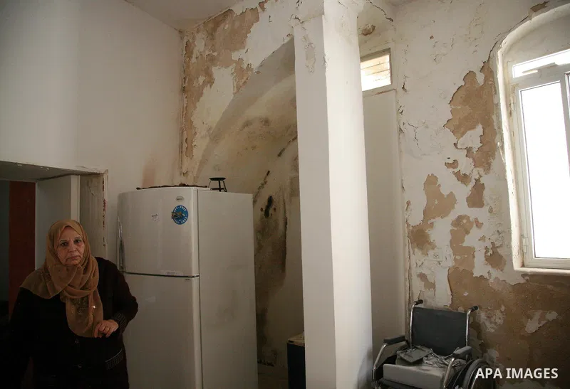 A Palestinian woman looks at the damage at her house which belong to a Palestinian Jerusalemite family because of building work carried out by Jewish settlers in Jerusalem's old city on May 1, 2011. Photo by Sliman Khade...