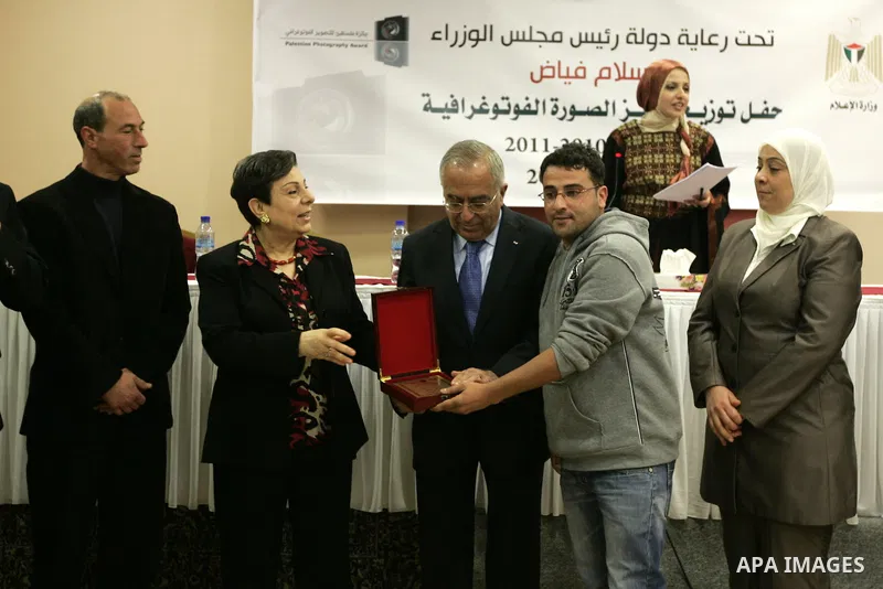 Palestinian prime minister Salam Fayyad attends a celebration to honor the photojournalists who won in the contest of "Palestine for Photography" at the Red Crescent hall in the West Bank city of Ramallah on May 2,2011....