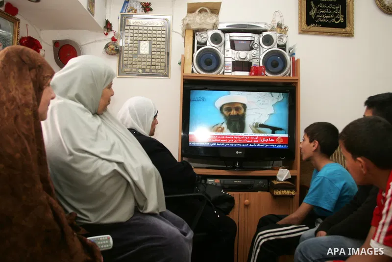 Members of Palestinian family watch a cable TV news report about the killing of Osama bin Laden, at their home in Jerusalem's old city on May 2, 2011. The United States has killed Al-Qaeda leader Osama bin Laden nearly 1...