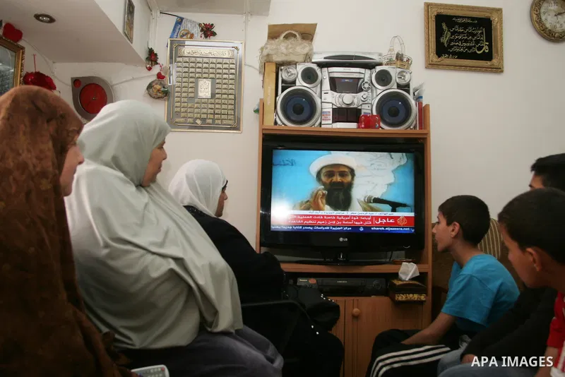 Members of Palestinian family watch a cable TV news report about the killing of Osama bin Laden, at their home in Jerusalem's old city on May 2, 2011. The United States has killed Al-Qaeda leader Osama bin Laden nearly 1...