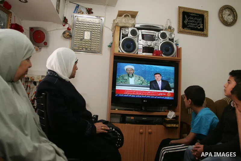 Members of Palestinian family watch a cable TV news report about the killing of Osama bin Laden, at their home in Jerusalem's old city on May 2, 2011. The United States has killed Al-Qaeda leader Osama bin Laden nearly 1...