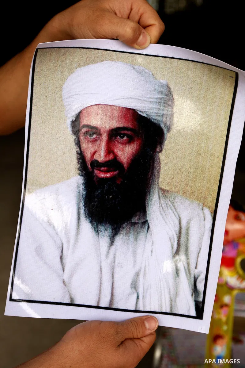Palestinians walk past a poster of Osama bin Laden, in the southern Gaza Strip town of Rafah on May 2, 2011. The United States has killed Al-Qaeda leader Osama bin Laden nearly 10 years after the September 11, 2001 attac...