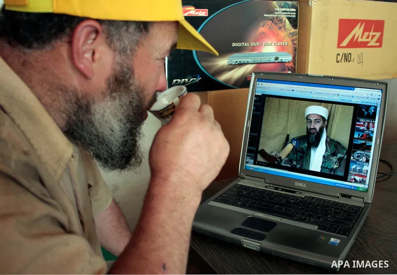 Palestinians read and watch news report about the killing of Osama bin Laden, at their shop in the West Bank city of Hebron on May 2, 2011. The United States has killed Al-Qaeda leader Osama bin Laden nearly 10 years aft...