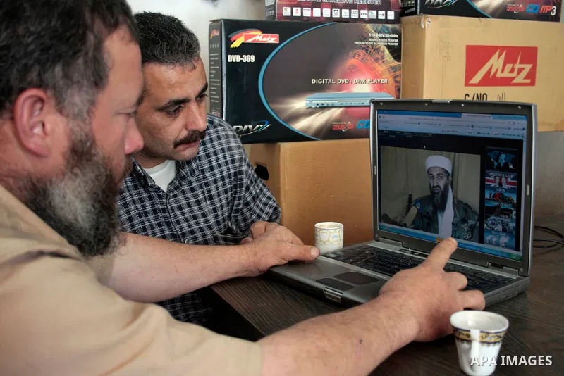 Palestinians read and watch news report about the killing of Osama bin Laden, at their shop in the West Bank city of Hebron on May 2, 2011. The United States has killed Al-Qaeda leader Osama bin Laden nearly 10 years aft...