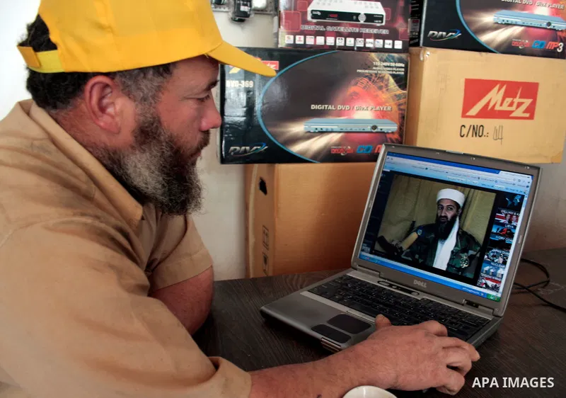Palestinians read and watch news report about the killing of Osama bin Laden, at their shop in the West Bank city of Hebron on May 2, 2011. The United States has killed Al-Qaeda leader Osama bin Laden nearly 10 years aft...
