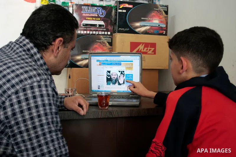 Palestinians read and watch news report about the killing of Osama bin Laden, at their shop in the West Bank city of Hebron on May 2, 2011. The United States has killed Al-Qaeda leader Osama bin Laden nearly 10 years aft...