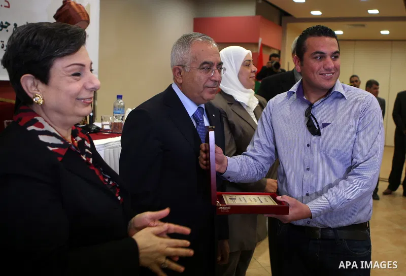 Palestinian prime minister Salam Fayyad honors APAimages photographer, Issam Rimawi during a celebration to honor the journalists who won in the contest of "Palestine for Photography" at the Red Crescent hall in the West...