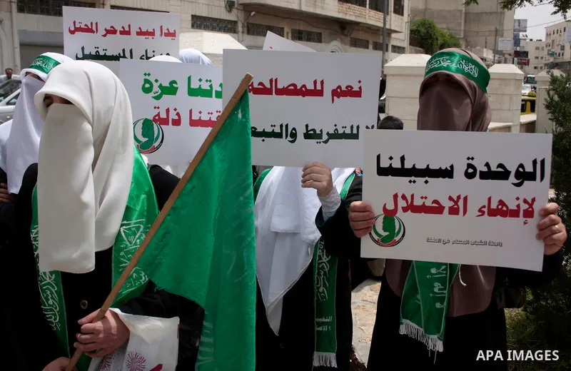 Palestinian women supporters of the Hamas Islamist movement demonstrate in the West Bank city of Hebron on May 04, 2011 as Palestinians in the West Bank and Gaza Strip gather to celebrate and welcome a reconciliation dea...