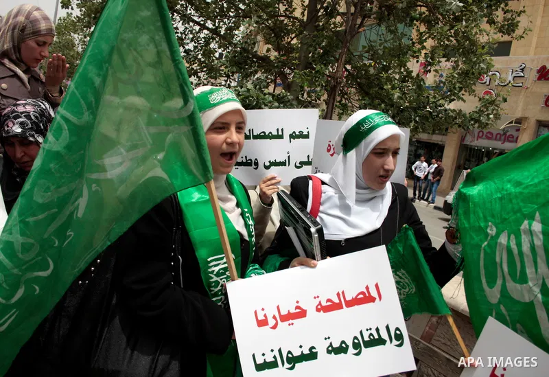 Palestinian women supporters of the Hamas Islamist movement demonstrate in the West Bank city of Hebron on May 04, 2011 as Palestinians in the West Bank and Gaza Strip gather to celebrate and welcome a reconciliation dea...