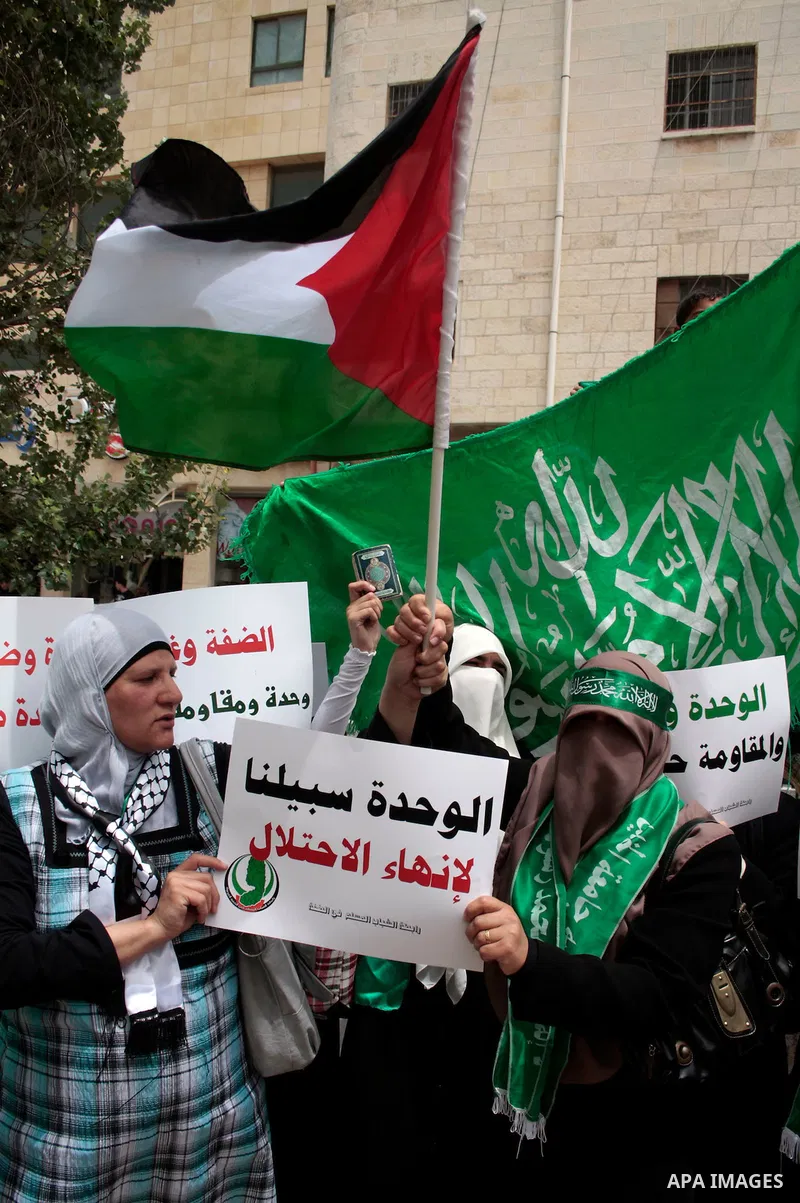 Palestinian women supporters of the Hamas Islamist movement demonstrate in the West Bank city of Hebron on May 04, 2011 as Palestinians in the West Bank and Gaza Strip gather to celebrate and welcome a reconciliation dea...
