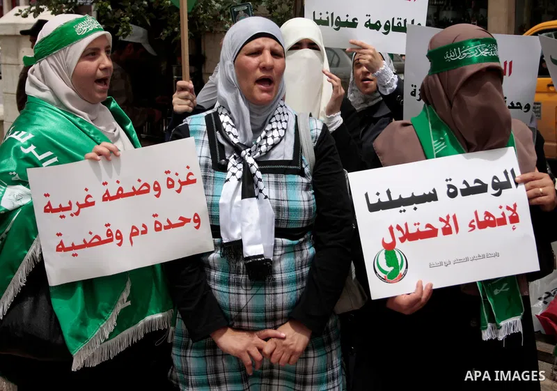 Palestinian women supporters of the Hamas Islamist movement demonstrate in the West Bank city of Hebron on May 04, 2011 as Palestinians in the West Bank and Gaza Strip gather to celebrate and welcome a reconciliation dea...