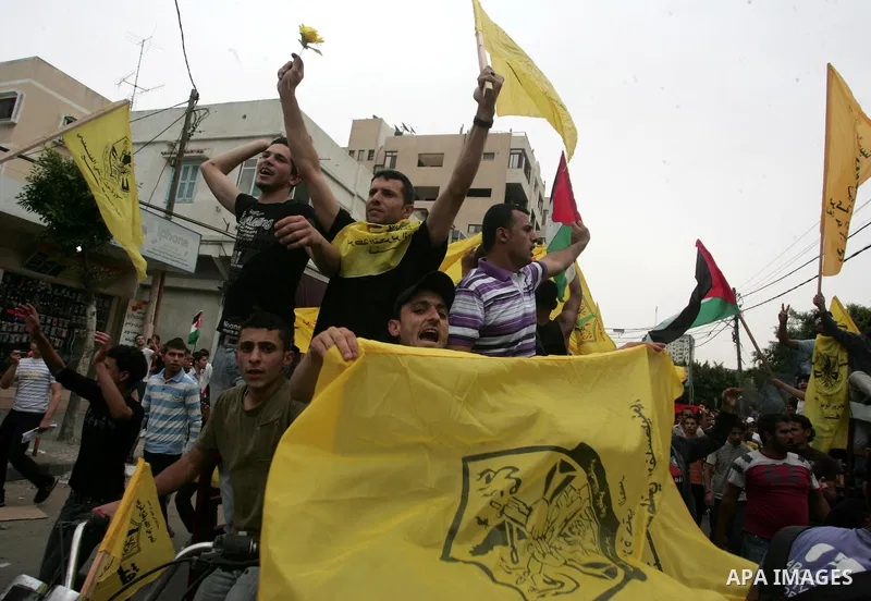 Palestinians wave with national flag and shout slogans during a rally celebrating the signing of a reconciliation deal in Gaza city on May 4,2011. Hundreds of Palestinians have gathered to cheer on a unity agreement bein...