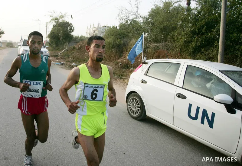 Palestinian Olympic athlete Nader Masri (R) and a fellow runner speed along the waterfront in Gaza City on May 5, 2011 as they compete in the Gaza Strip's first-ever marathon which runs the entire length of the coastal e...