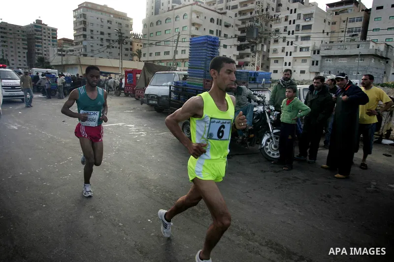 Palestinian Olympic athlete Nader Masri runs past a fish market in Gaza City on May 5, 2011 as he competes in the Gaza Strip's first-ever marathon which runs the entire length of the coastal enclave. Photo by Mohammed Ot...