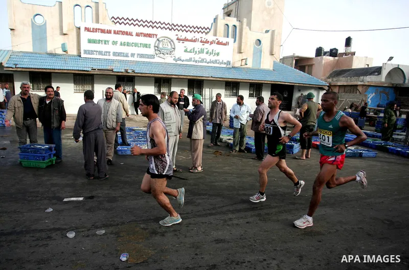 Palestinian racers runs past a fish market in Gaza City on May 5, 2011 as he competes in the Gaza Strip's first-ever marathon which runs the entire length of the coastal enclave. Photo by Mohammed Othman
