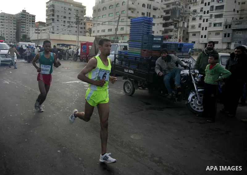 Palestinian Olympic athlete Nader Masri runs past a fish market in Gaza City on May 5, 2011 as he competes in the Gaza Strip's first-ever marathon which runs the entire length of the coastal enclave. Photo by Mohammed Ot...